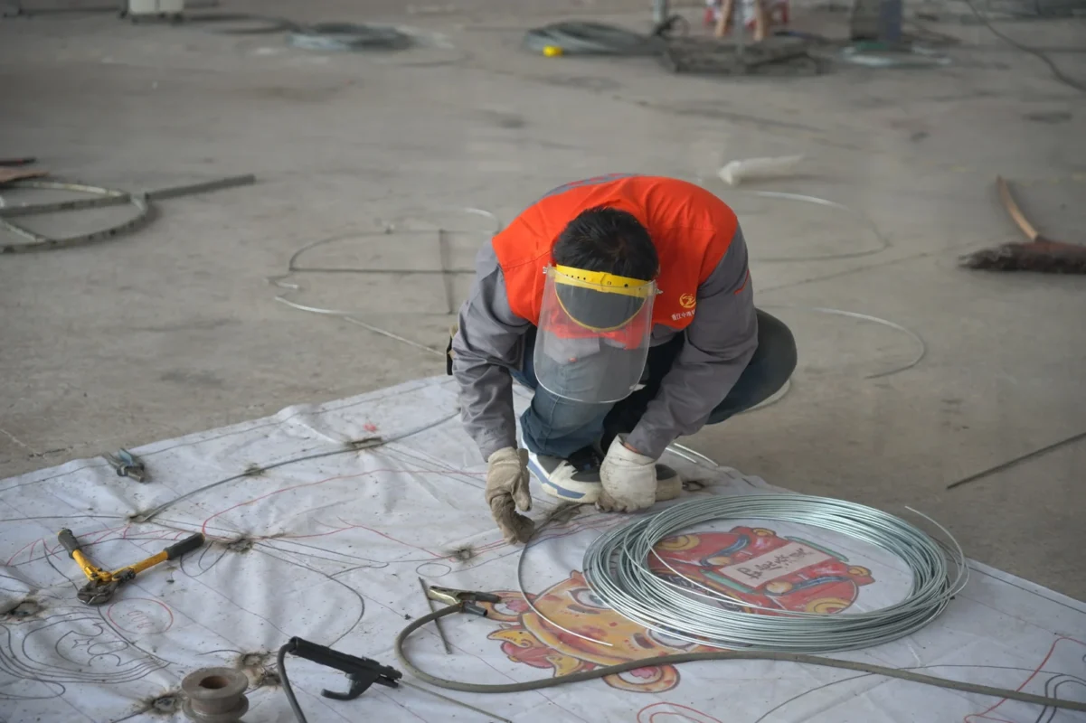 A maker cutting material against a lantern pattern.