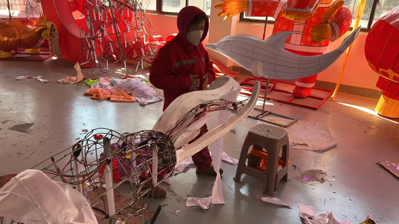Fabric and surface work around a shaped lantern framework.