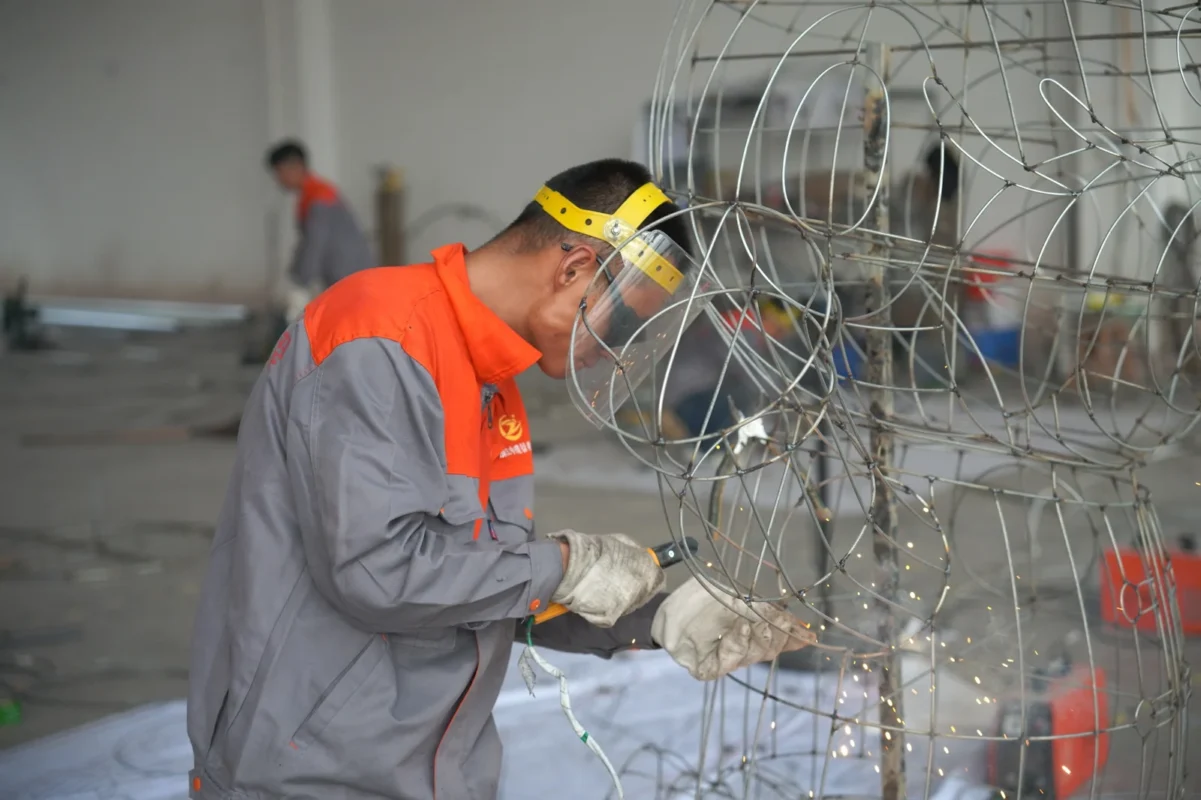 A maker working on the curved wire framework.